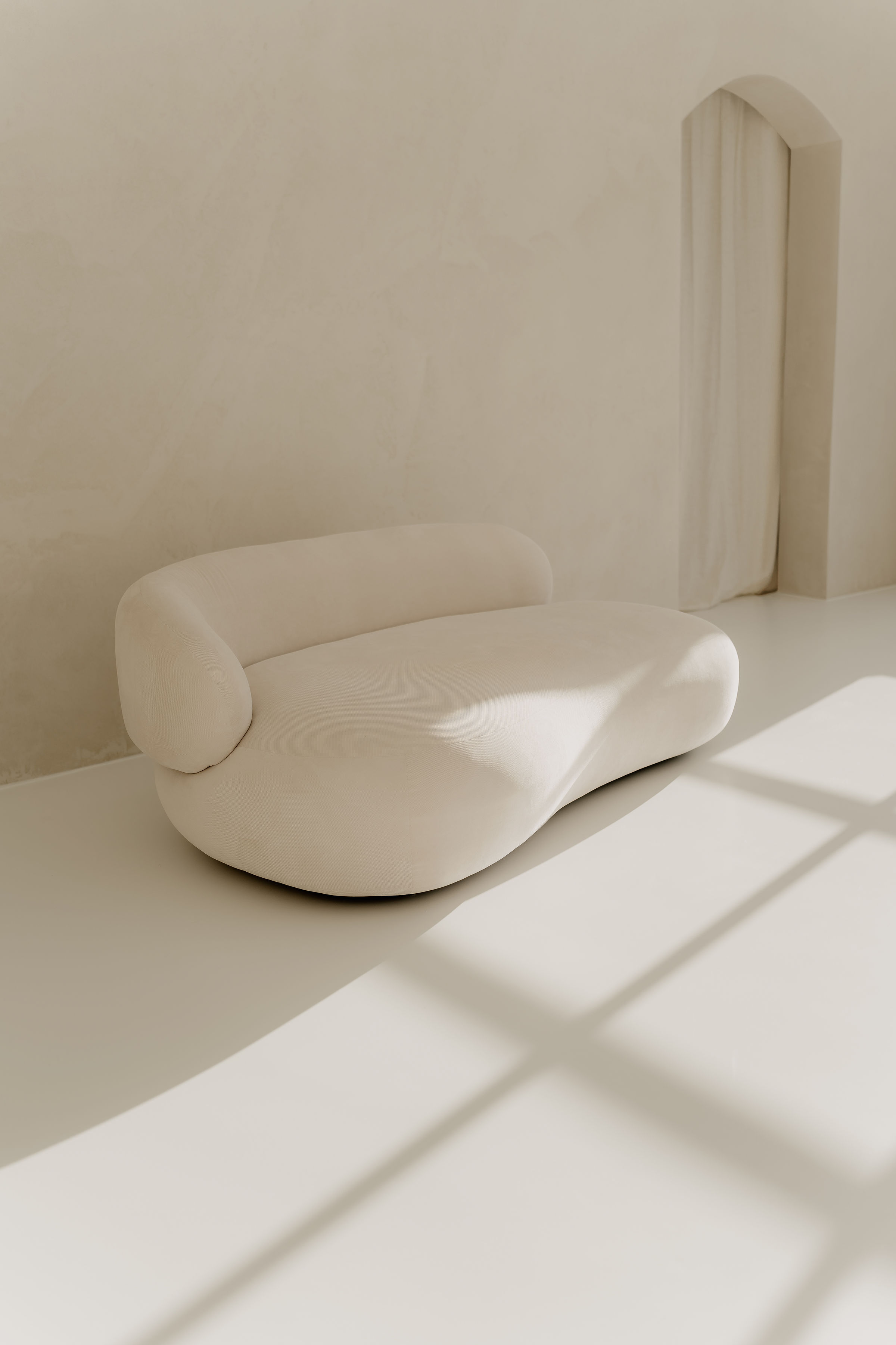 Landloft Studio - Minimalistisches Sofa mit Bogentür und natürlichem Licht