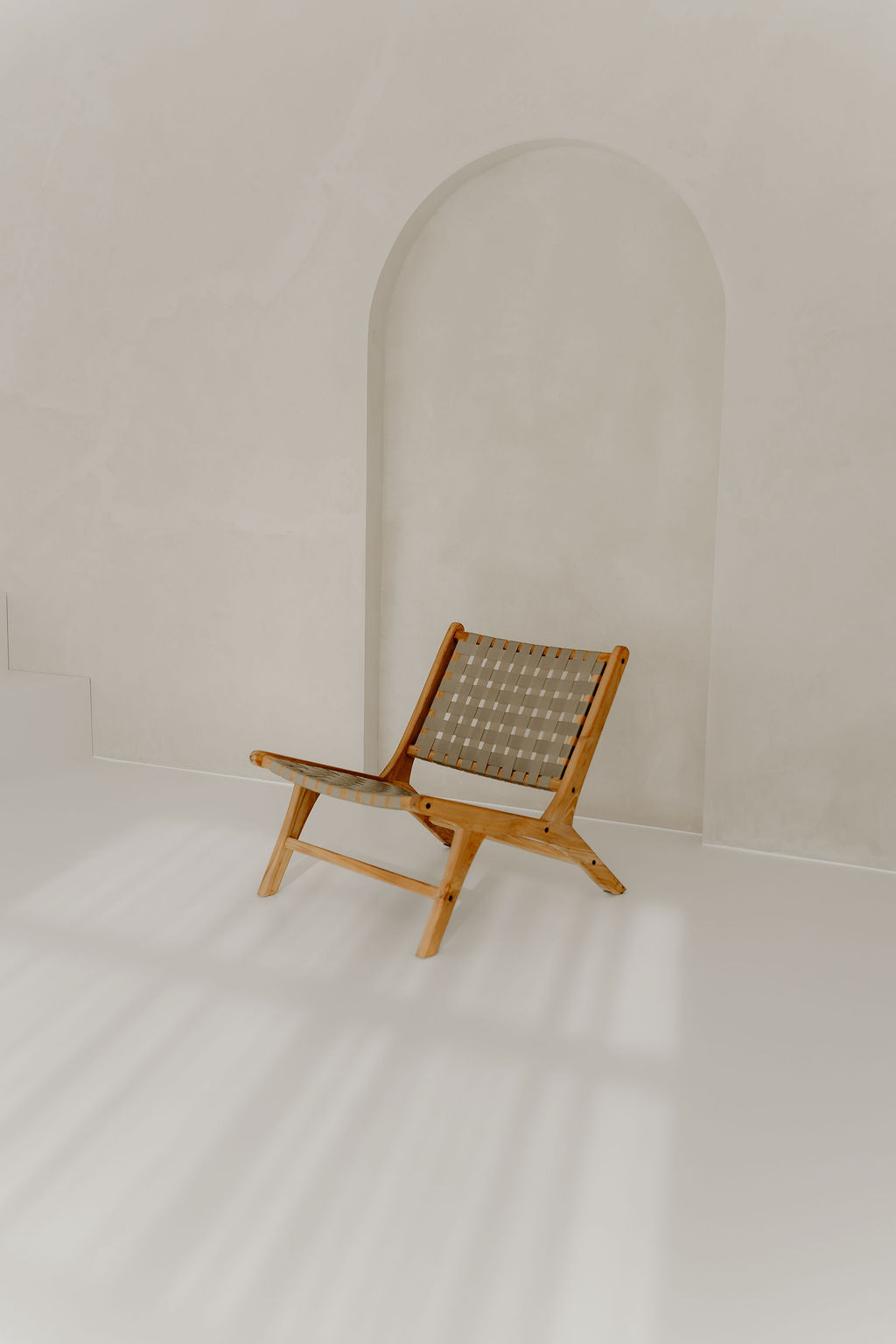 Landloft Studio - Woven wooden chair in front of arched niche
