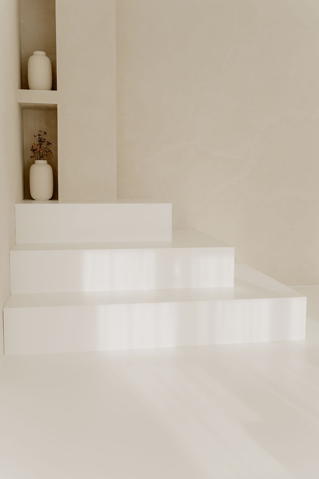 Landloft Studio - Minimalist steps with ceramic vases and dried flowers