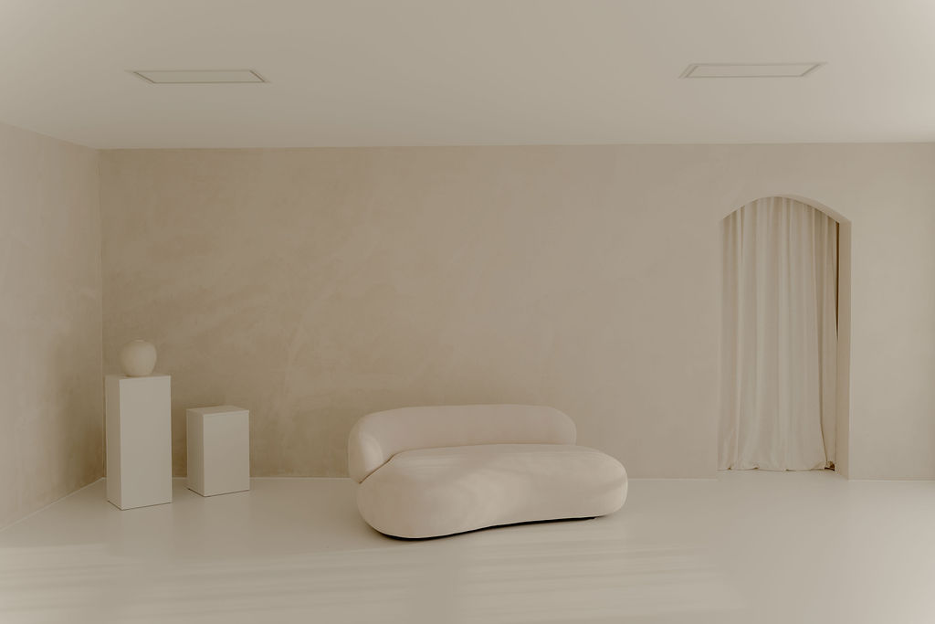 Landloft Studio - Wide studio shot with sofa, pedestals and curtained arch