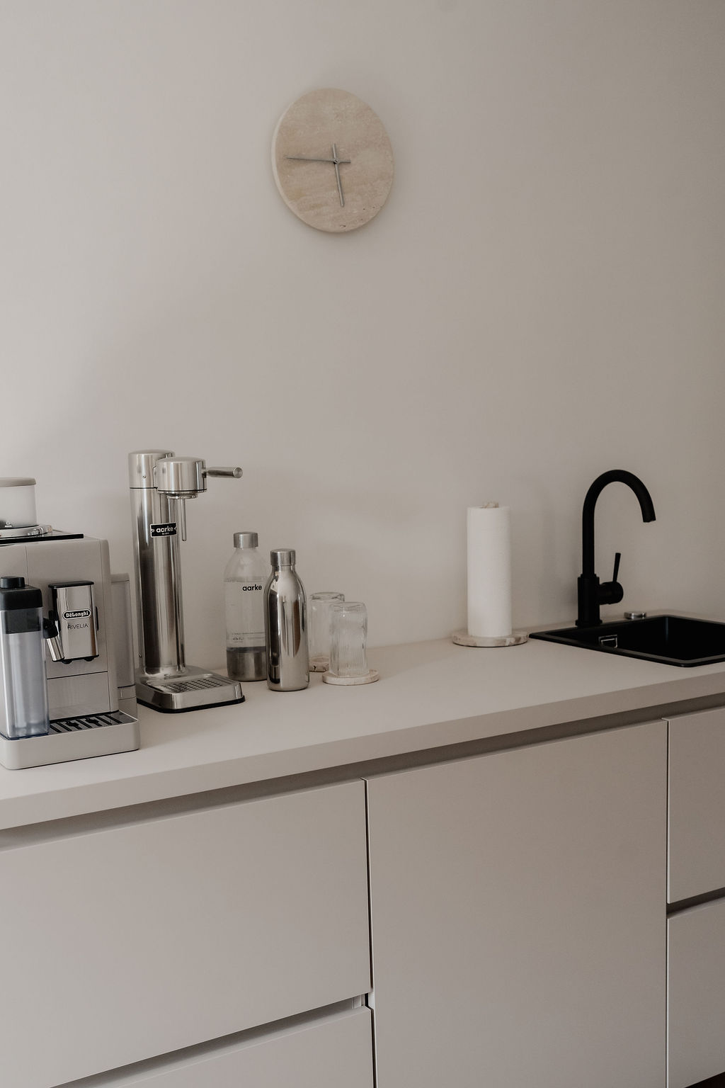 Landloft Studio - Minimalistische Küchenzeile mit Kaffeemaschine und schwarzem Wasserhahn